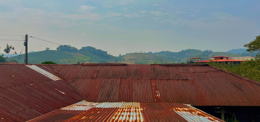 Dach eines Farmhauses mit Bergen im Hintergrund